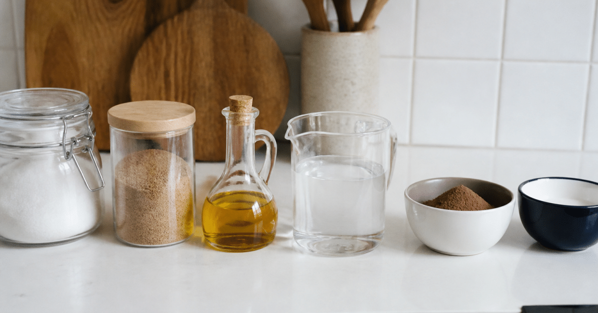 Ingredients et contenants alignes sur plan de travail blanc