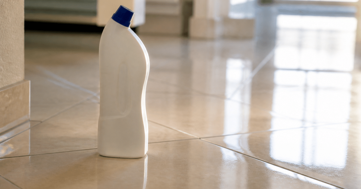 Bouteille de produit nettoyant posee sur sol carrelage brillant