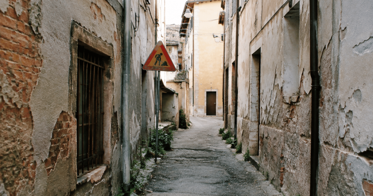 Ruelles etroites degradees avec batiments delabres et panneaux d'avertissement