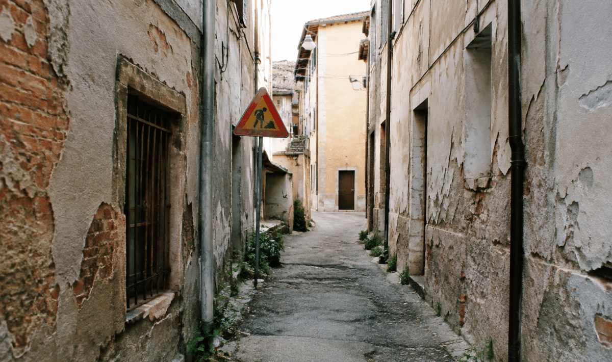 Ruelles etroites degradees avec batiments delabres et panneaux d'avertissement