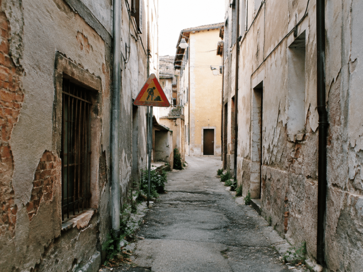 Ruelles etroites degradees avec batiments delabres et panneaux d'avertissement