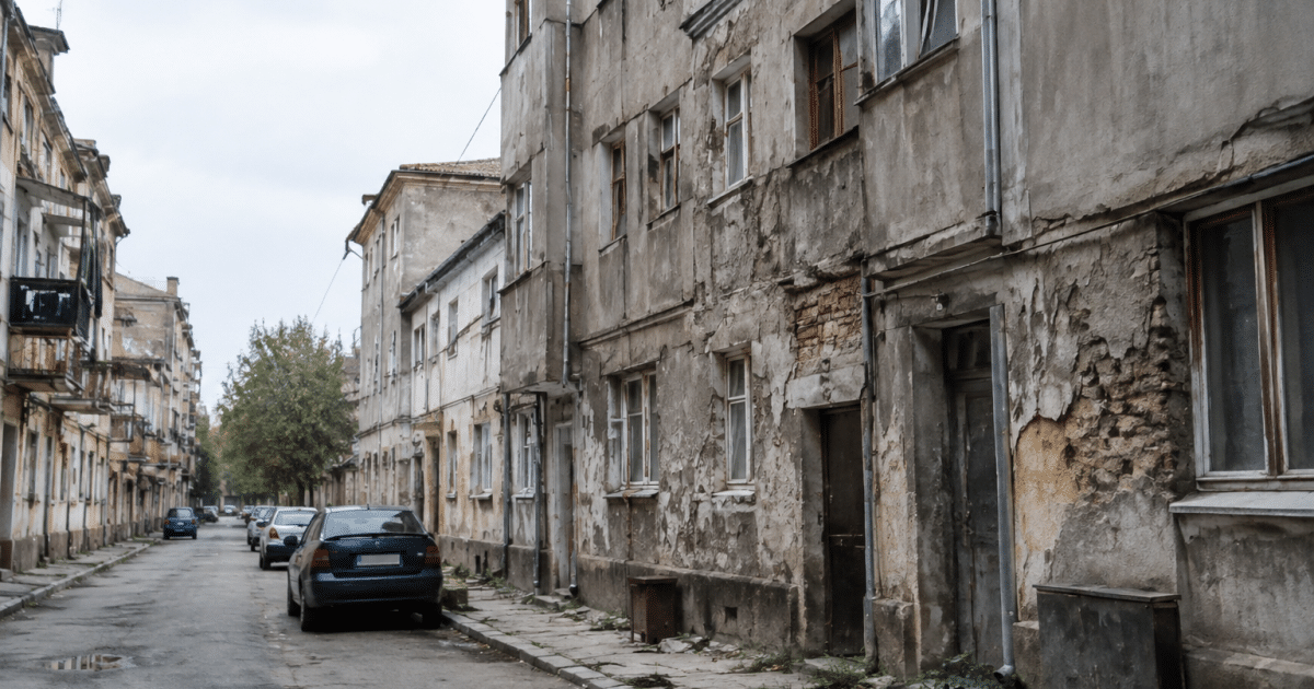 Rue urbaine delabree avec batiments deteriores et facades grisatres