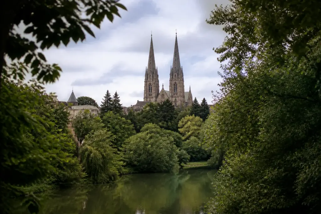 Cathedrale aux deux fleches surplombant une riviere verdoyante